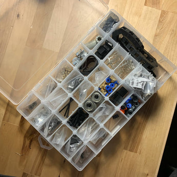 Open organizer box with ERCF hardware kit parts, bearings, belt, fittings, fasteners, and cable chain