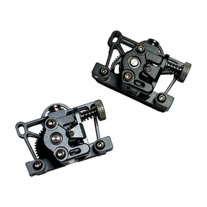 Two black FYSETC CNC machined aluminum Sherpa Mini extruders with tension screws and drive gears on a white background