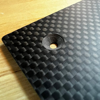 Close-up of LH Stinger matte woven carbon fiber bed plate with countersunk mounting hole