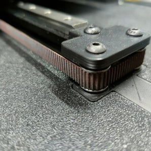 Close-up of the Voron Switchwire 9mm Y-axis belt mod showing the wider GT2 belt running around stacked idler bearings.